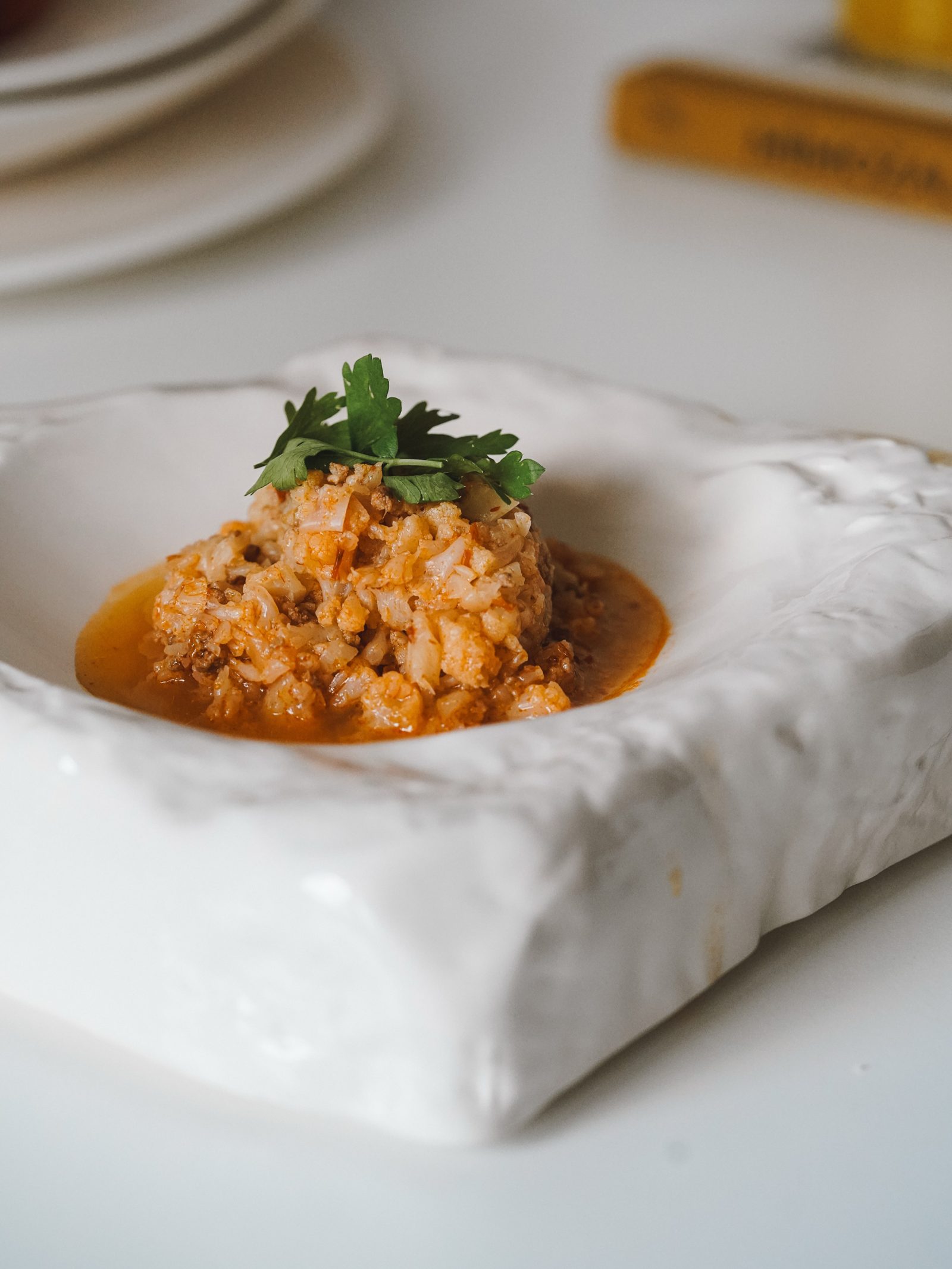 Dalgalı yüzeyli, heykelsi beyaz seramik tabakta risotto